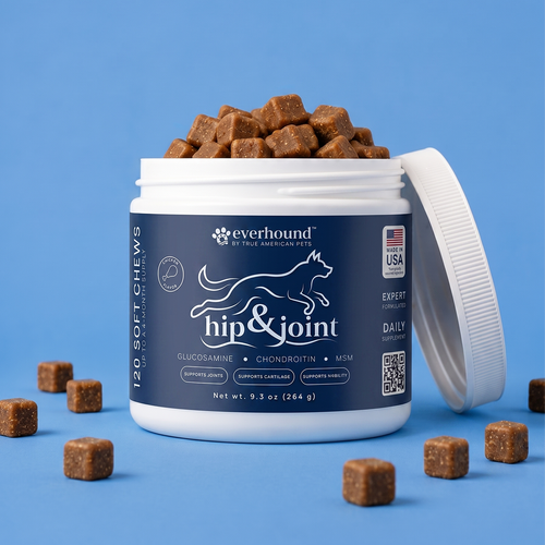 A white plastic jar of Everhound Hip & Joint supplement with a navy blue label, shown open with brown chew cubes spilling out on a solid blue background.